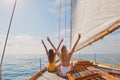 Two cheerful friends with arms raised making peace signs celebrating on boat cruise together. Two excited women in Royalty Free Stock Photo