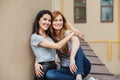 Two cheerful girls hugging in the street