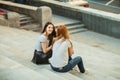 Two cheerful girls sitting on the stairs Royalty Free Stock Photo