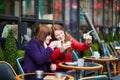 Two cheerful girls taking selfie in a Parisian cafe Royalty Free Stock Photo