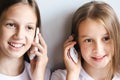 Two cheerful girls are talking on white old-fashioned push-button telephones Royalty Free Stock Photo