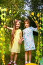 Two cheerful girls walk through a beaded curtain in nature