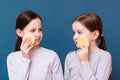 Two cheerful girls wash themselves with face sponges on a blue background. Child Hygiene Concept