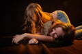 Two cheerful joyfull sisters having fun together in dark studio with black background