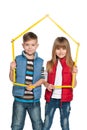 Two children are holding model of a house