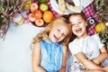 Two cheerful kids lying on a picnic blanket among refreshments Royalty Free Stock Photo