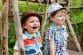 Two cheerful little boys in hats sitting on a bench in the Park Royalty Free Stock Photo
