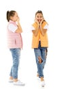 Two cheerful little girls share secrets in each other s ear. Royalty Free Stock Photo