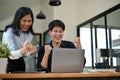 Two cheerful and overjoyed Asian office workers are celebrating their project success together Royalty Free Stock Photo