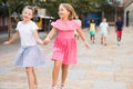 Two cheerful preteen girls enjoying walk along city street Royalty Free Stock Photo
