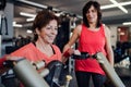 Two cheerful seniors women in gym doing strength workout exercise. Royalty Free Stock Photo