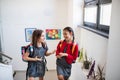 Two cheerful small school girl friends with bags walking up the stairs. Royalty Free Stock Photo