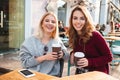 Two cheerful smiling girls holding coffee cups Royalty Free Stock Photo