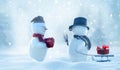 Two cheerful snowman standing in winter christmas landscape. Winter fairytale.Snowfall in the magic forest.Merry christmas and Royalty Free Stock Photo