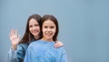 two cheerful teen girls hand on shoulder toothy smile look camera isolated on blue color wall background Royalty Free Stock Photo