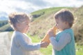 Two cheerful toddler girls on country road