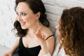 Two cheerful woman enjoying shopping together jewellery boutique. Sister giving present jewelry earrings