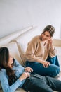 Two cheerful woman friend sitting on a sofa and talking with each other Royalty Free Stock Photo