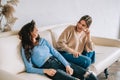 Two cheerful woman friend sitting on a sofa and talking with each other Royalty Free Stock Photo