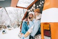 Two cheerful women friends sitting in a van in winter camp and having fun, enjoying holiday Royalty Free Stock Photo