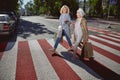 Two cheerful women laughing and going down the city street Royalty Free Stock Photo