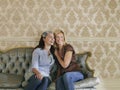 Two Cheerful Women Sitting On Sofa Royalty Free Stock Photo