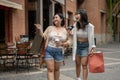 Two cheerful young Asian women friends are enjoying talking during their shopping day in the city Royalty Free Stock Photo