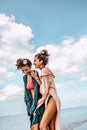 Two cheerful young stylish woman twin sisters having fun on the beach Royalty Free Stock Photo