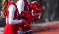 Two cheerleaders with red and white pom poms