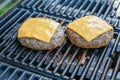 Two cheese burgers on a warm grill