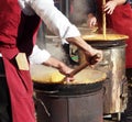 Two chef cook polenta in the traditional way of north east italy on small wood-fired cookers Royalty Free Stock Photo