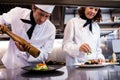 Two chefs garnishing meal on counter Royalty Free Stock Photo