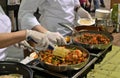 Two Chefs at a natural products trade show are Sampling Food and conducting a Food Demo Royalty Free Stock Photo