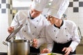 Two chefs in team in hotel or restaurant kitchen Royalty Free Stock Photo