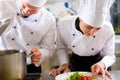 Two chefs in team in hotel or restaurant kitchen Royalty Free Stock Photo