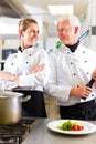 Two chefs in team in hotel or restaurant kitchen Royalty Free Stock Photo