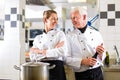 Two chefs in team in hotel or restaurant kitchen Royalty Free Stock Photo