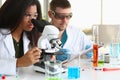 Two chemistry students conduct microscopic examinations in laboratory