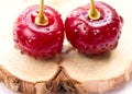Two cherries on a wooden board