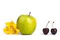 Two cherry berries and one big green apple on white background isolated close up macro