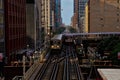 Two of Chicago`s elevated `el` train on tracks above the city, transporting commuters during rush hour. Royalty Free Stock Photo