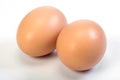 Two chicken brown eggs are close on a white background Royalty Free Stock Photo