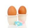 Two chicken eggs in holder with flowers