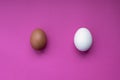 Two chicken eggs - white and brown - on a pink background. Royalty Free Stock Photo