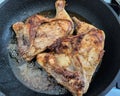 Two chicken legs are fried in a pan in a large amount of oil Royalty Free Stock Photo