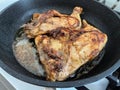 Two chicken legs are fried in a pan in a large amount of oil Royalty Free Stock Photo