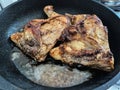 Two chicken legs are fried in a pan in a large amount of oil Royalty Free Stock Photo