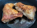 Two chicken legs are fried in a pan in a large amount of oil Royalty Free Stock Photo