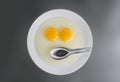 Two chicken Raw egg yolks and stainless spoon Royalty Free Stock Photo