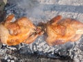 Two chickens roasting on grill